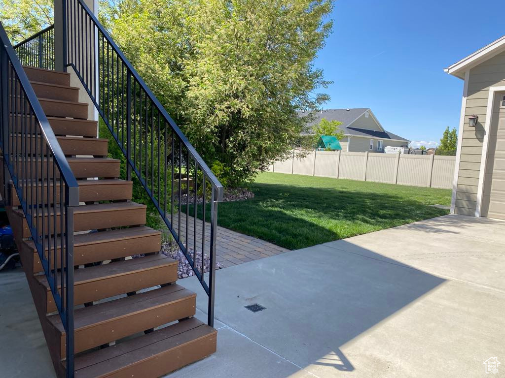 Exterior space featuring fence, stairs, and a patio area