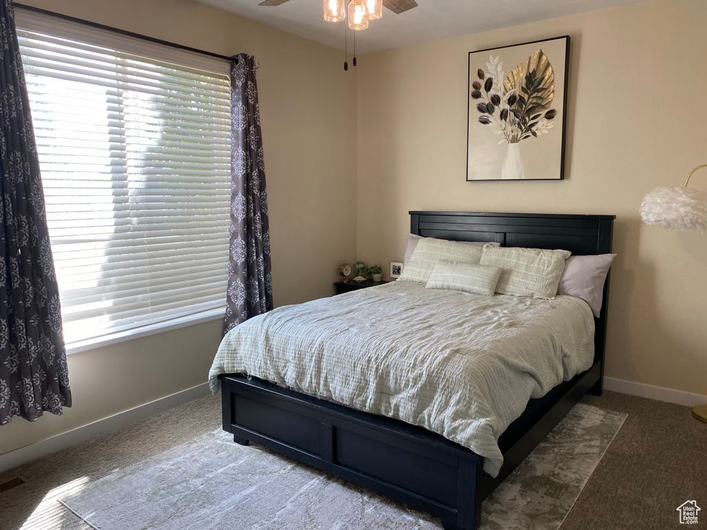 Bedroom featuring baseboards, multiple windows, and carpet