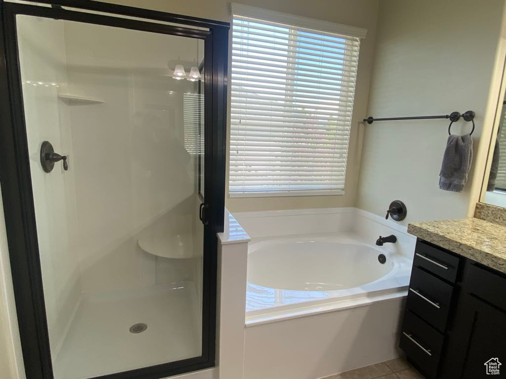 Bathroom with a shower stall, a bath, and vanity