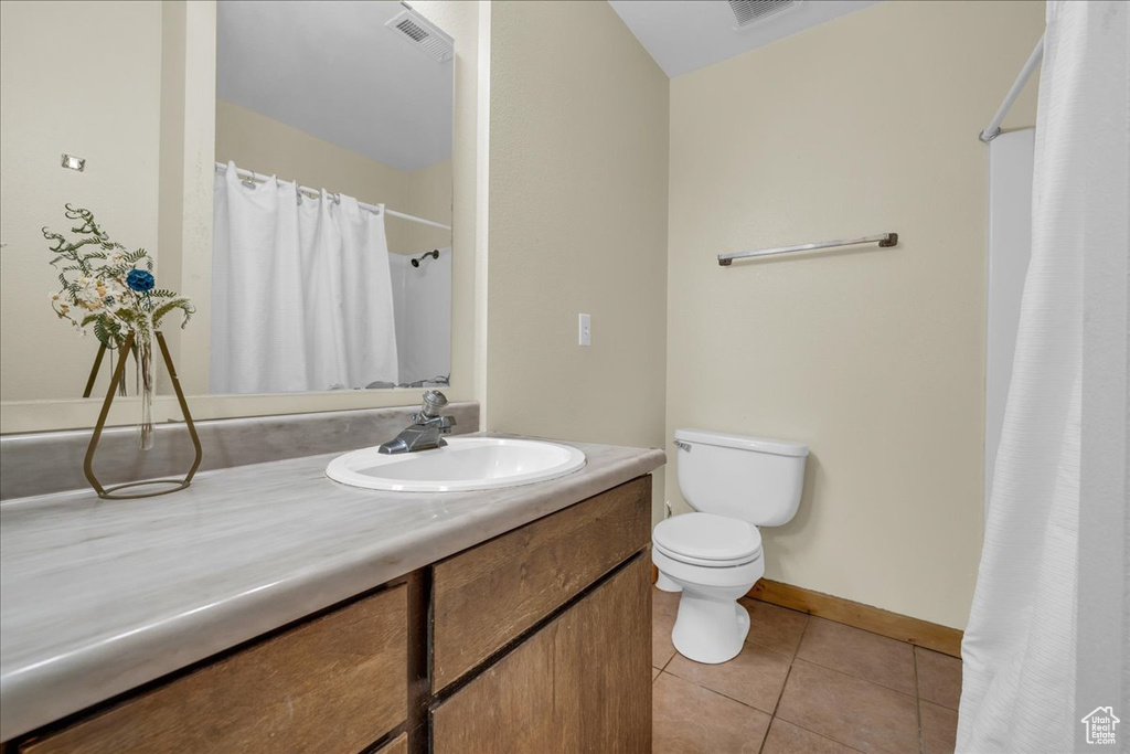Full bath with vanity, curtained shower, toilet, baseboards, and tile patterned floors