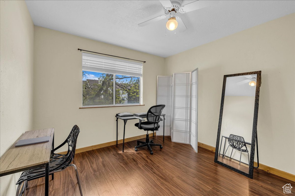 Office space with baseboards, a ceiling fan, and wood finished floors