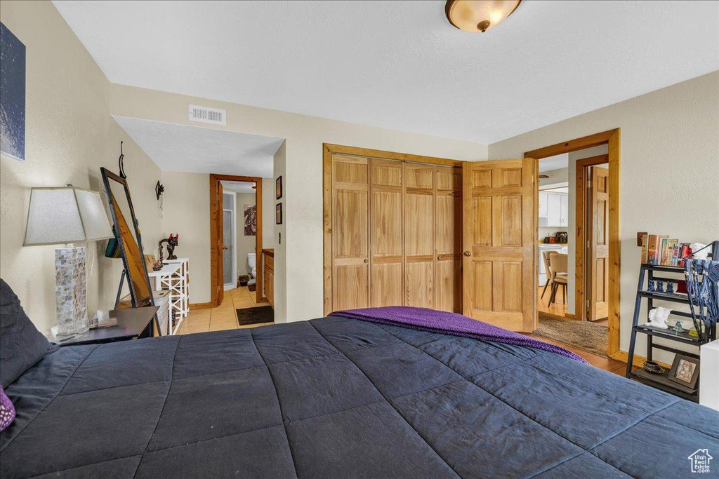Bedroom with baseboards, tile patterned flooring, a closet, and visible vents