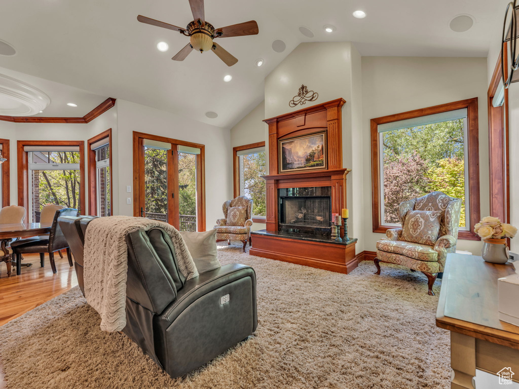 Living room with a fireplace with raised hearth, a ceiling fan, recessed lighting, and wood finished floors