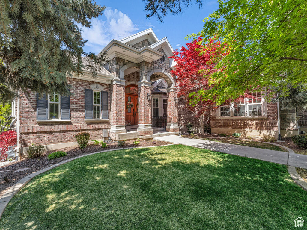 View of front of house featuring brick siding and a front yard