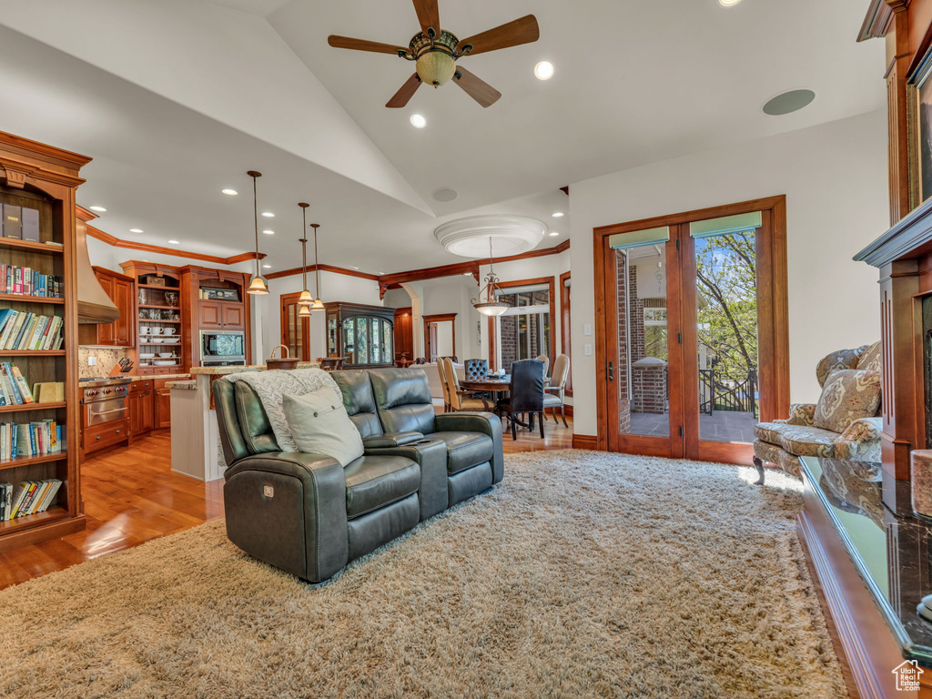 Living area with french doors, a ceiling fan, recessed lighting, lofted ceiling, and light wood-type flooring