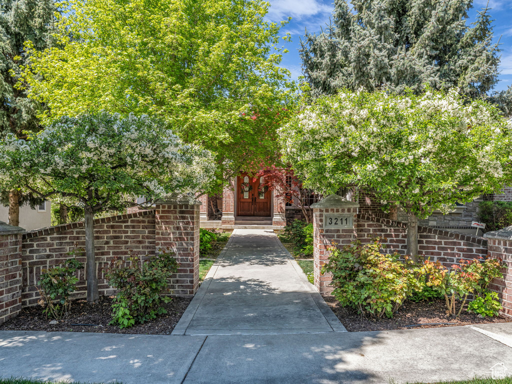 View of exterior entry featuring fence and brick siding
