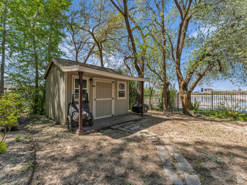 View of shed featuring fence and a water view