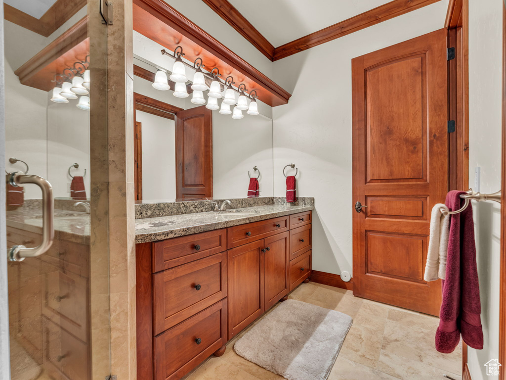 Bathroom with vanity, ornamental molding, and a stall shower