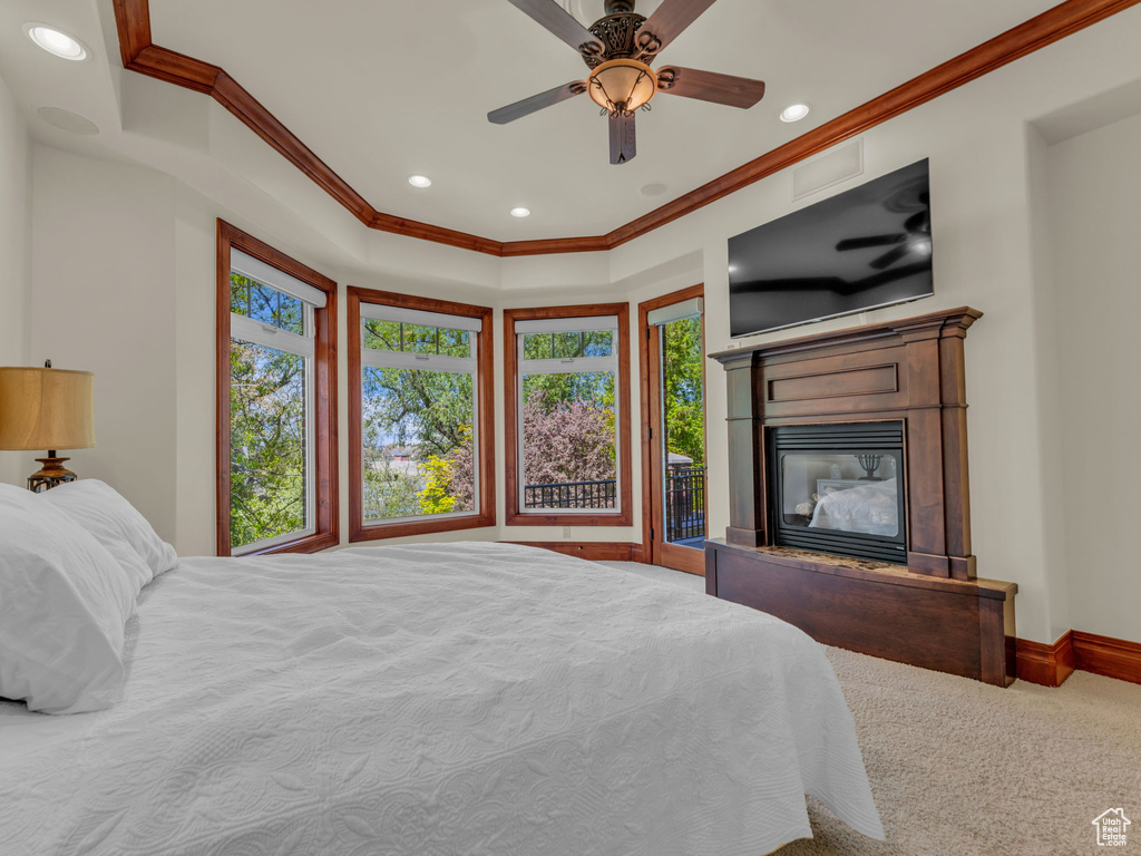 Bedroom with crown molding, a glass covered fireplace, baseboards, recessed lighting, and a ceiling fan