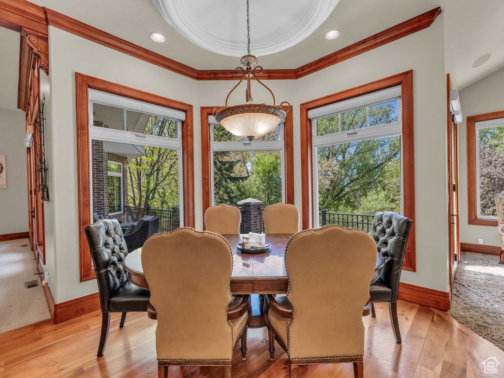 Dining space with light wood-type flooring, ornamental molding, and baseboards