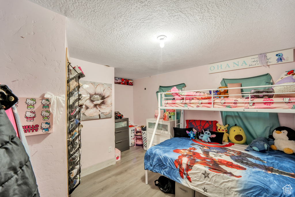 Bedroom featuring a textured ceiling and wood finished floors