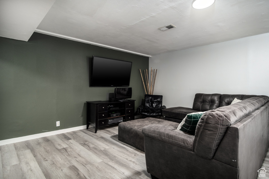 Living room with visible vents, baseboards, and wood finished floors