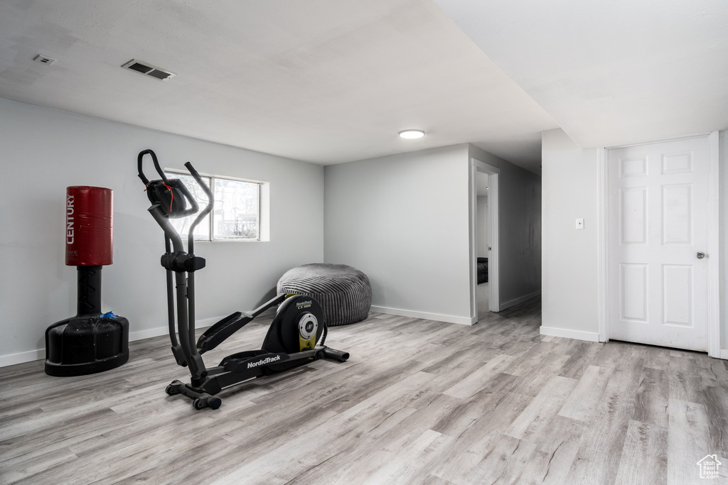 Exercise room with baseboards, wood finished floors, and visible vents