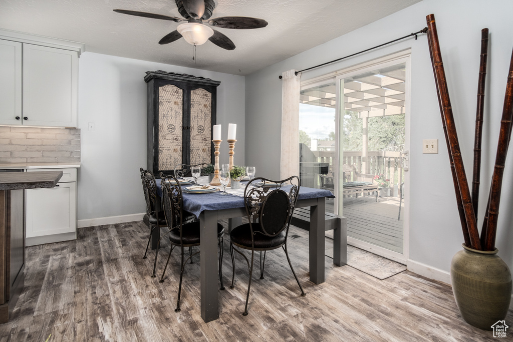Dining room with baseboards, a ceiling fan, and wood finished floors