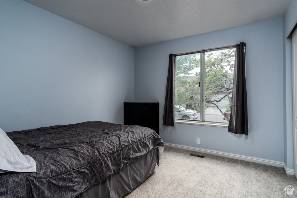 Bedroom featuring carpet flooring, baseboards, and visible vents