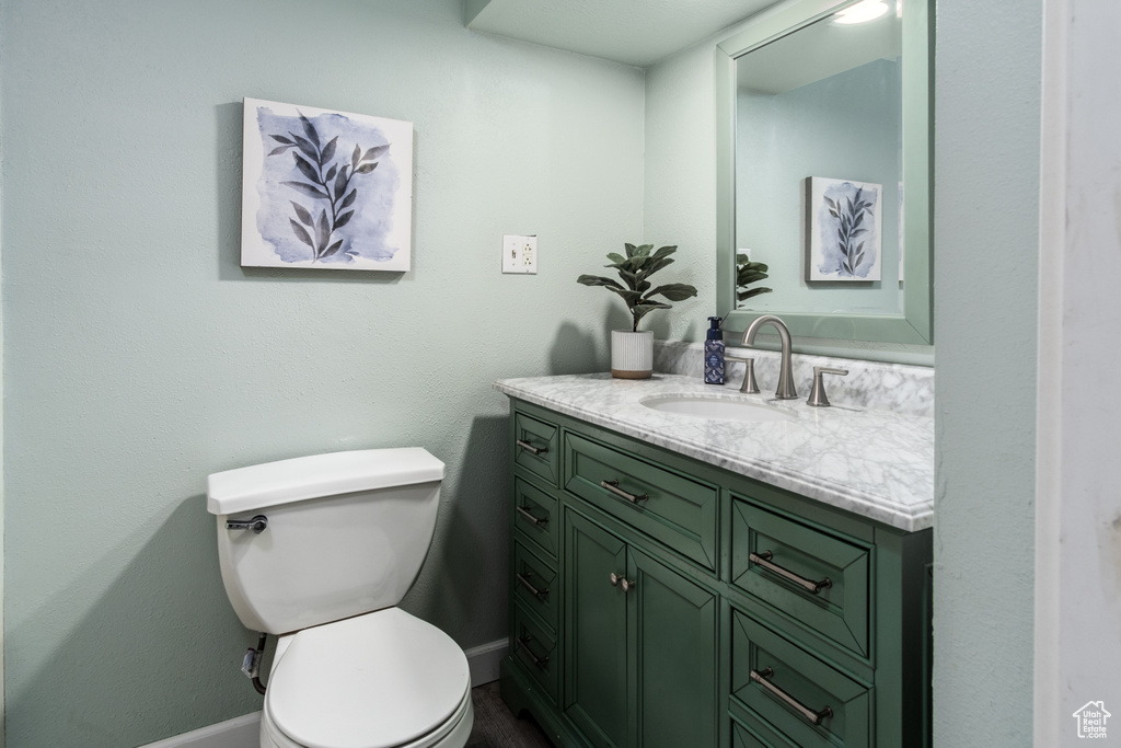 Bathroom featuring vanity, baseboards, and toilet