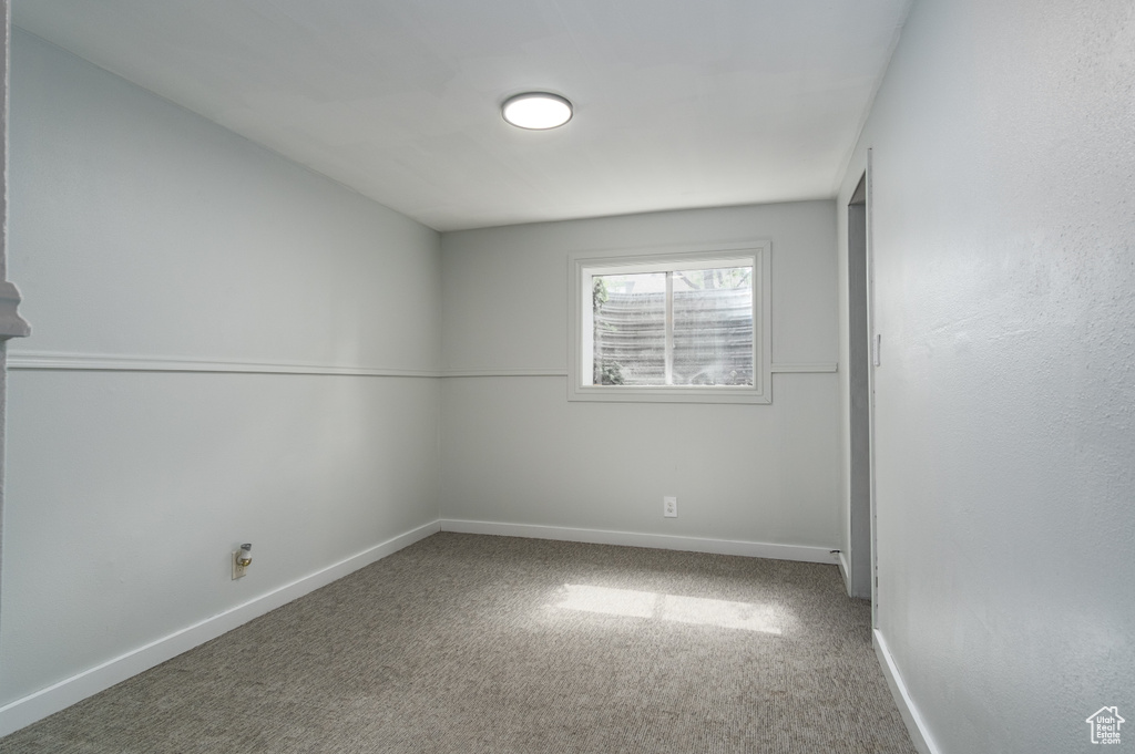 Carpeted empty room featuring baseboards