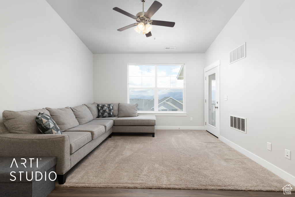Living room with visible vents, a ceiling fan, and baseboards