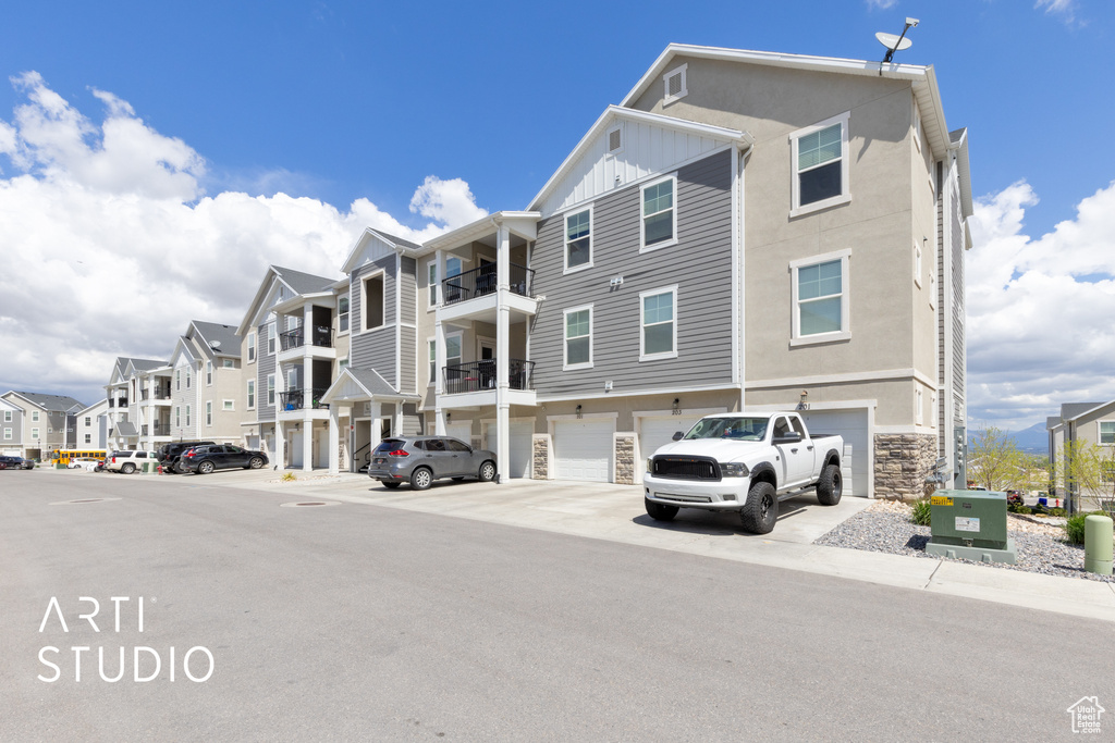 View of building exterior featuring driveway, a residential view, and a garage