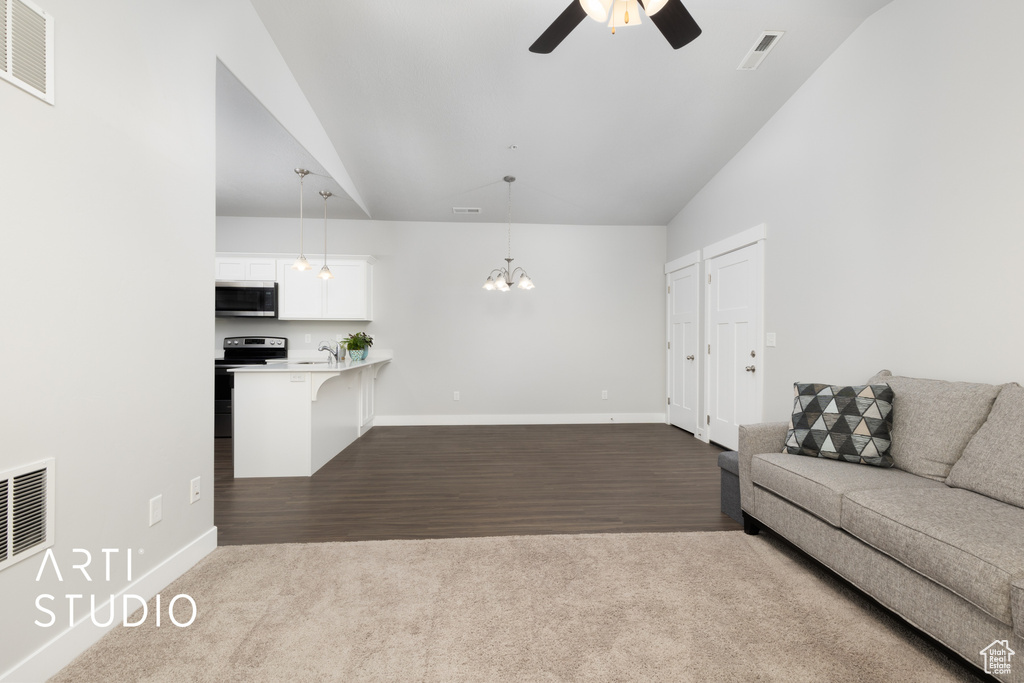 Unfurnished living room featuring ceiling fan with notable chandelier, dark wood-style flooring, and visible vents