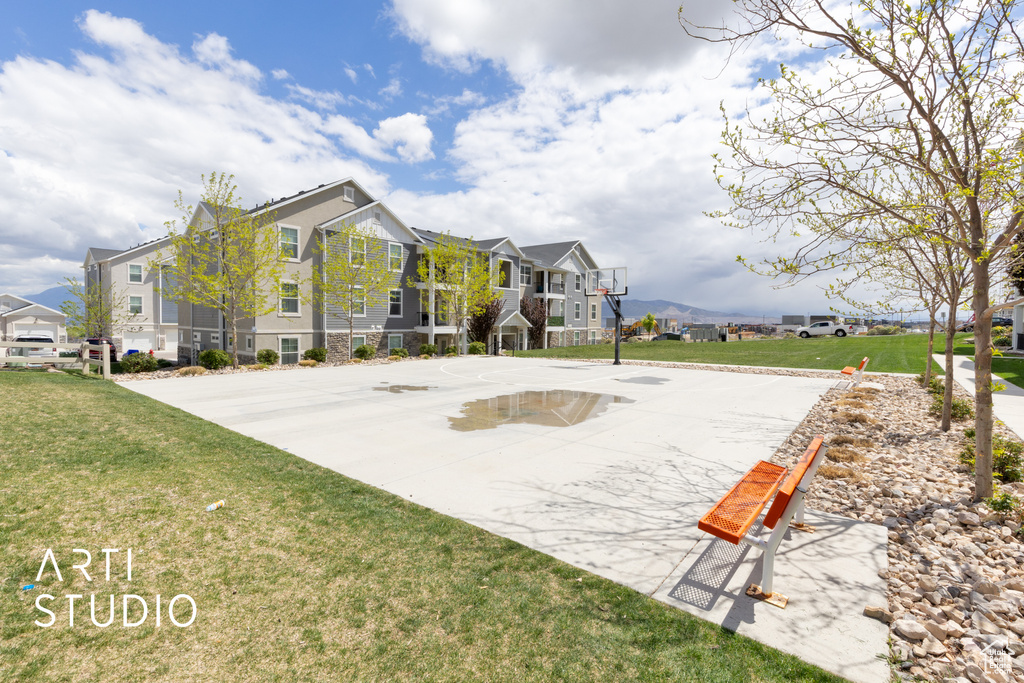 Exterior space featuring a residential view, community basketball court, and a lawn