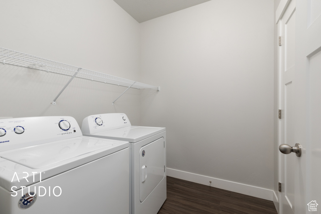 Washroom with laundry area, baseboards, washer and dryer, and dark wood-style floors