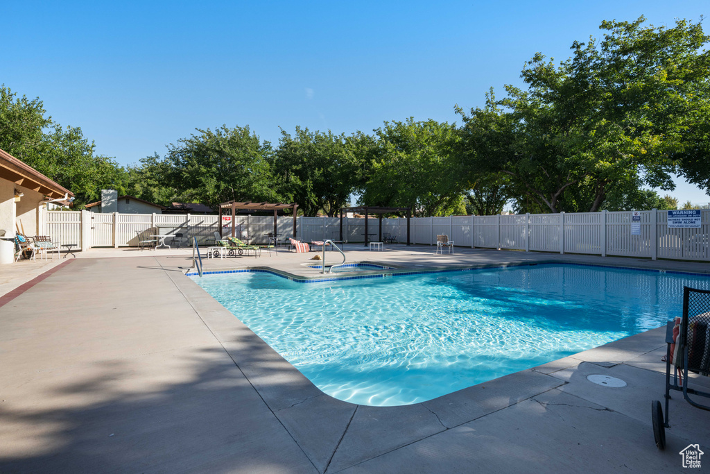 Community pool with a patio and fence
