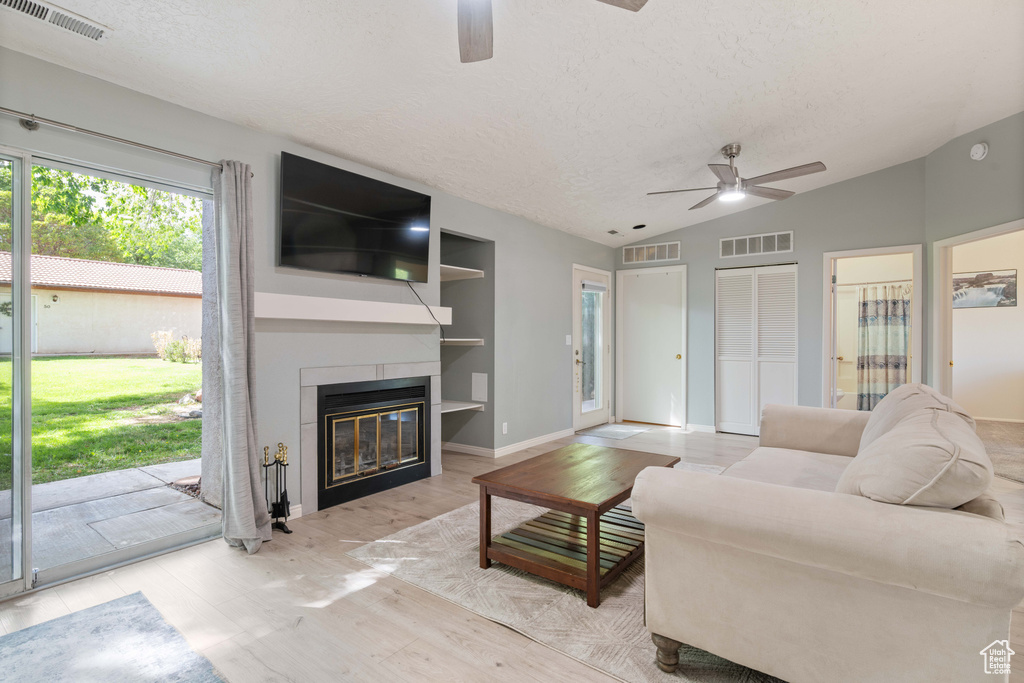 Living room featuring a ceiling fan, a textured ceiling, and visible vents