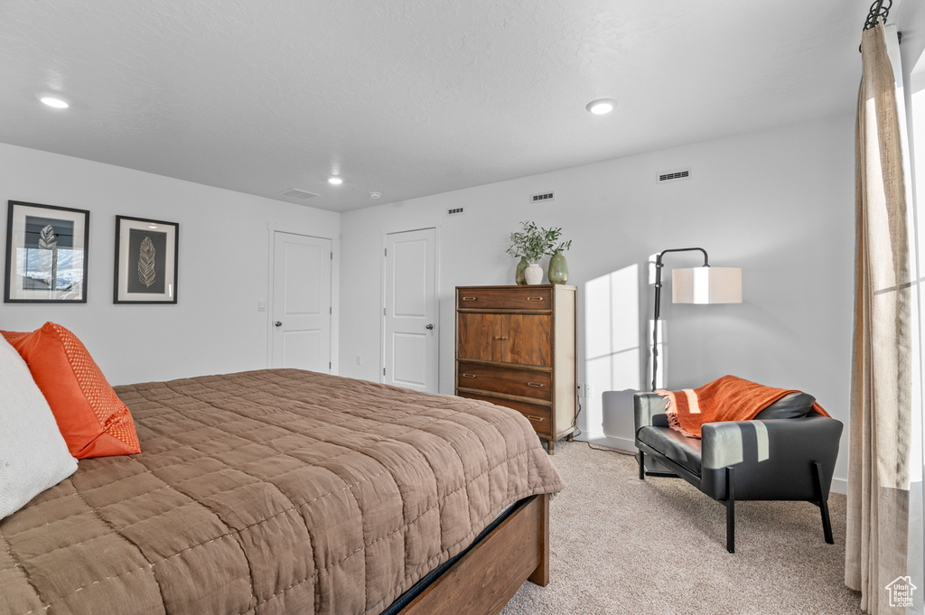 Bedroom featuring light colored carpet, recessed lighting, and visible vents