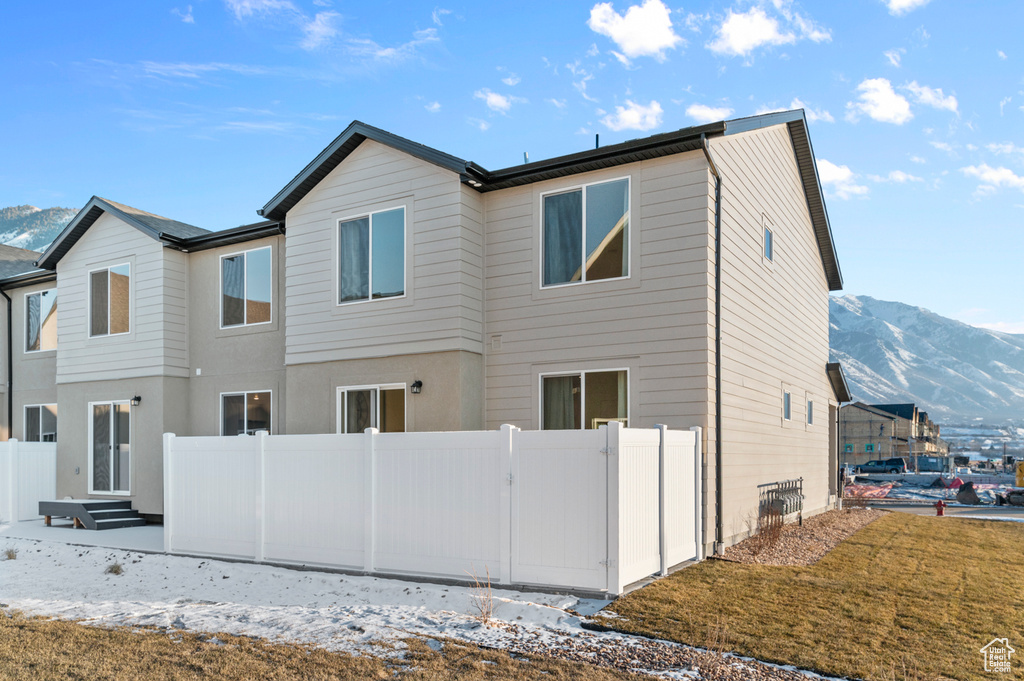 Rear view of house with fence and a mountain view