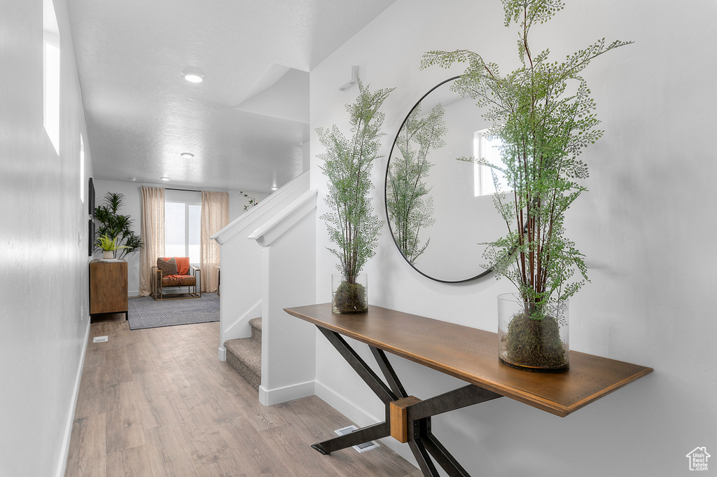 Entrance foyer featuring stairs, baseboards, and wood finished floors