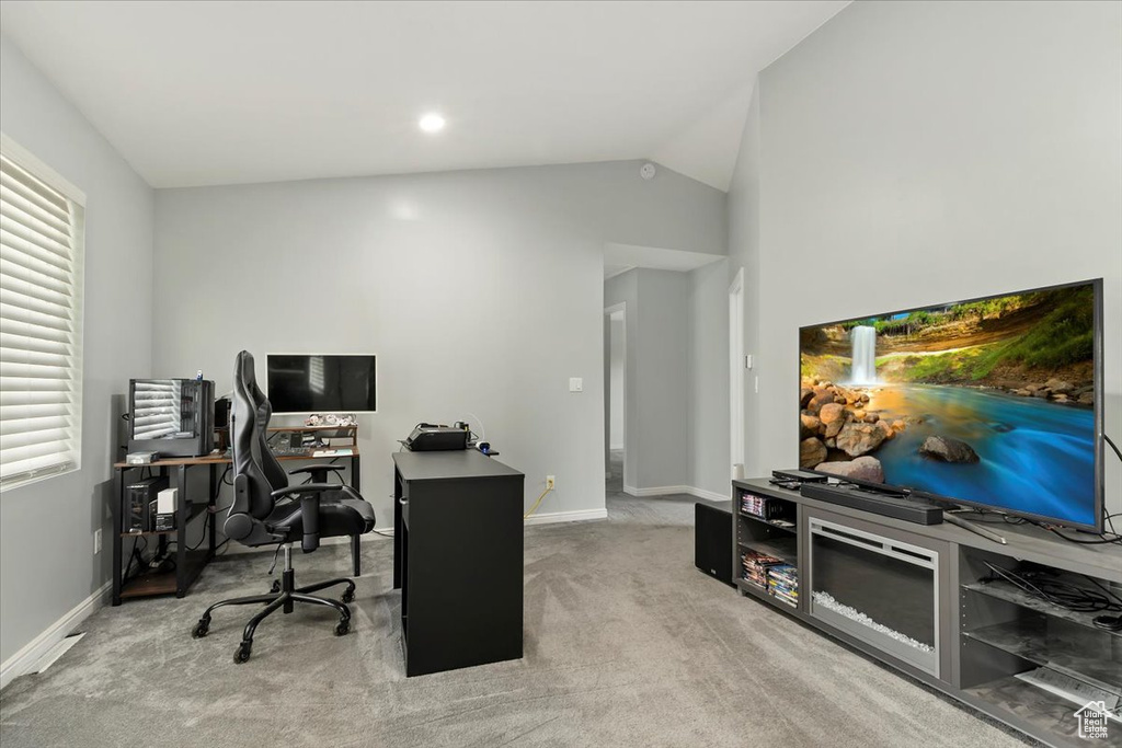 Carpeted home office featuring baseboards and lofted ceiling