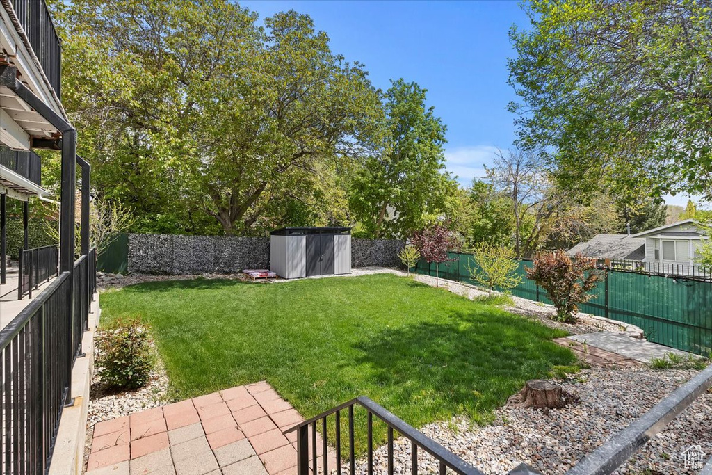 View of yard featuring a fenced backyard, a shed, and an outbuilding