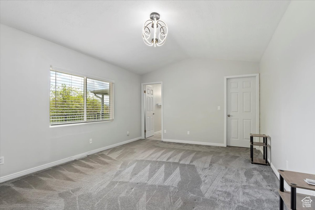 Unfurnished bedroom featuring baseboards, carpet, and lofted ceiling