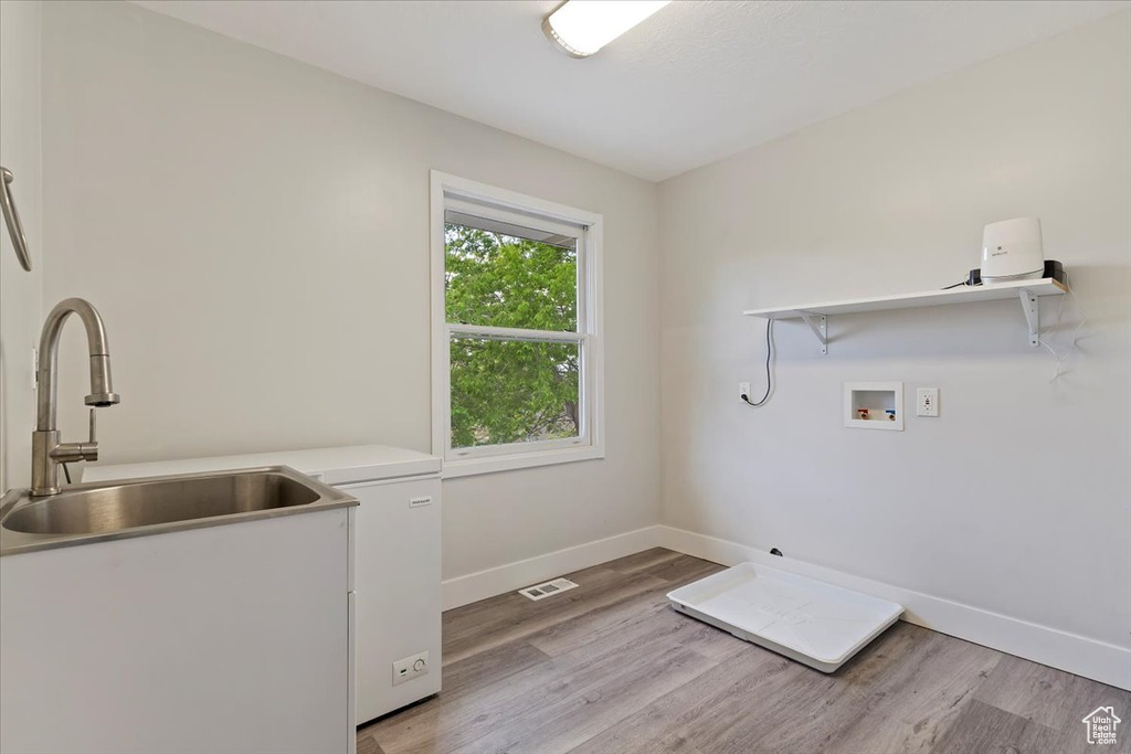 Laundry area featuring washer hookup, laundry area, visible vents, baseboards, and light wood-style floors