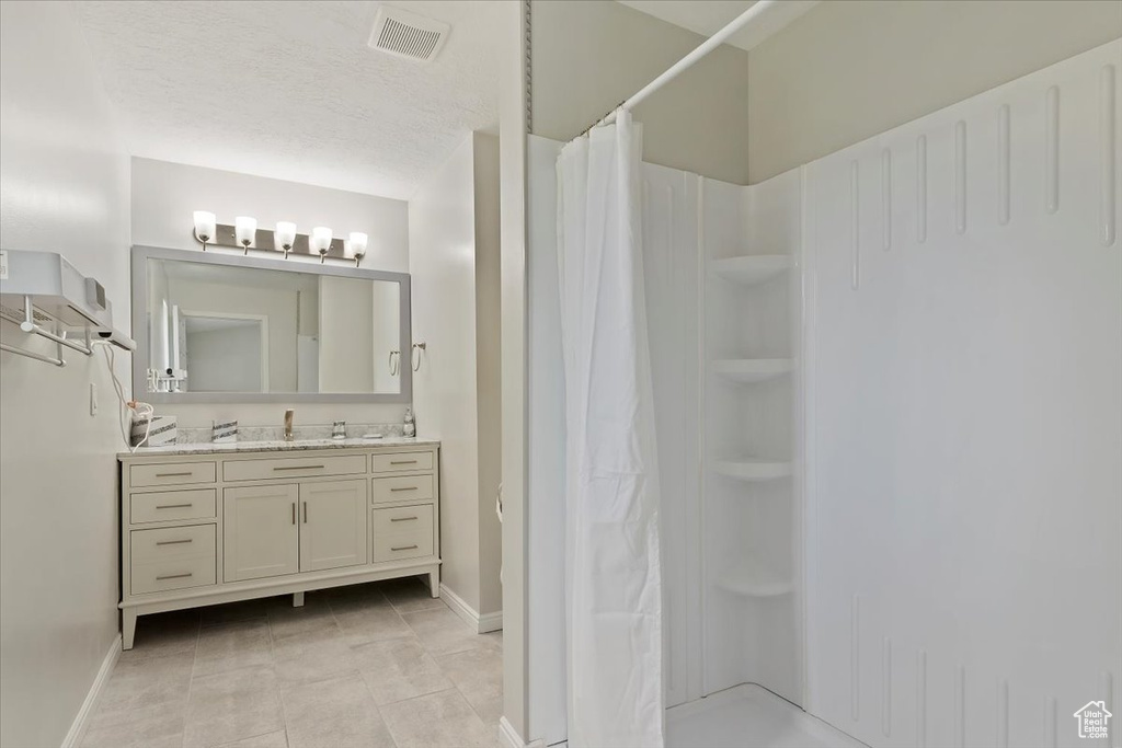 Full bath with baseboards, visible vents, and a shower with shower curtain