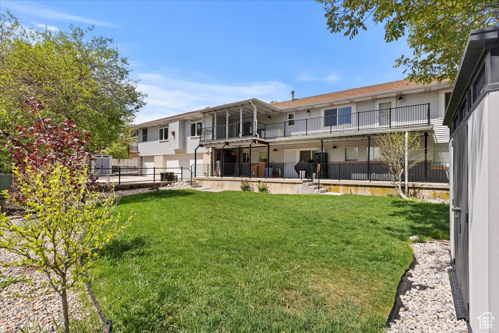 Rear view of property with a yard and fence