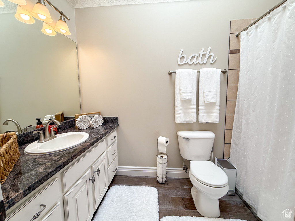 Full bathroom with vanity, baseboards, toilet, and curtained shower