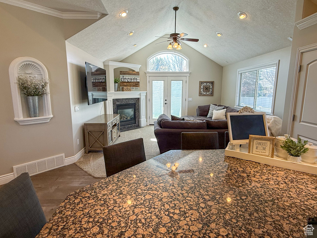Living room featuring a ceiling fan, a textured ceiling, visible vents, wood finished floors, and a premium fireplace