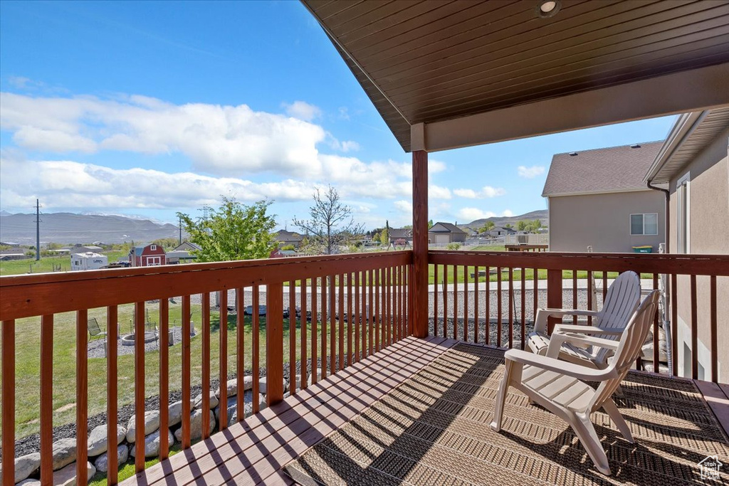 Wooden terrace featuring a lawn, a residential view, and a mountain view