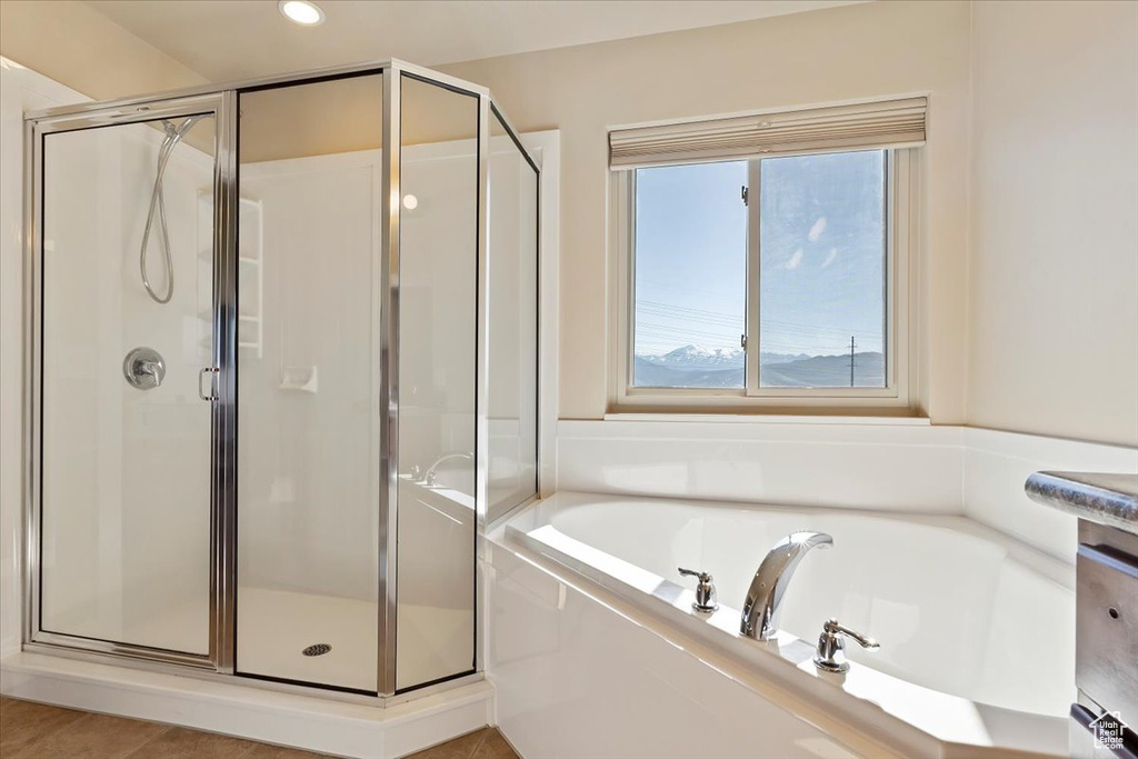 Bathroom featuring recessed lighting, a garden tub, and a stall shower