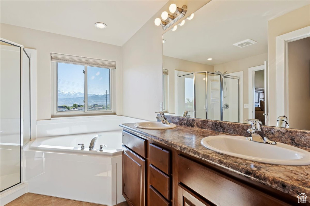 Full bathroom with a garden tub, a sink, double vanity, and a shower stall