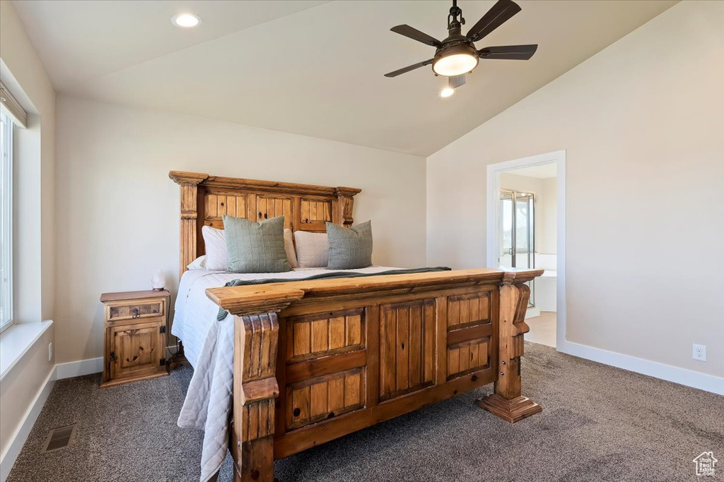 Bedroom with baseboards, visible vents, vaulted ceiling, and dark colored carpet