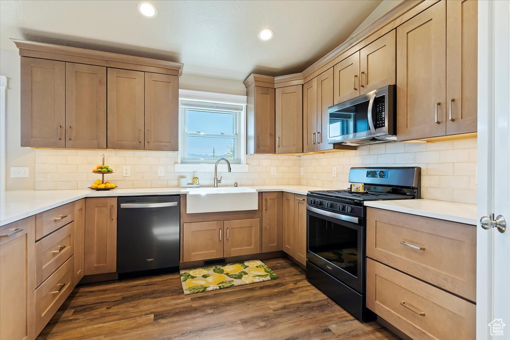 Kitchen with dishwashing machine, light countertops, stainless steel microwave, a sink, and gas stove