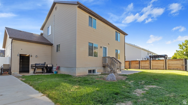Back of house featuring a lawn, a fenced backyard, and a patio area