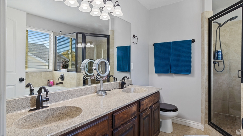 Full bathroom featuring a sink, tile patterned floors, toilet, and a shower stall