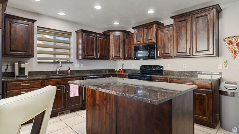 Kitchen featuring dark brown cabinets, a sink, recessed lighting, light tile patterned floors, and black appliances