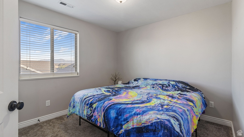 Bedroom with carpet floors, baseboards, and visible vents