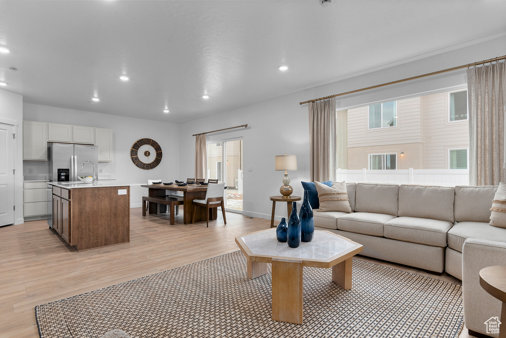 Living room with recessed lighting, baseboards, and light wood-style floors