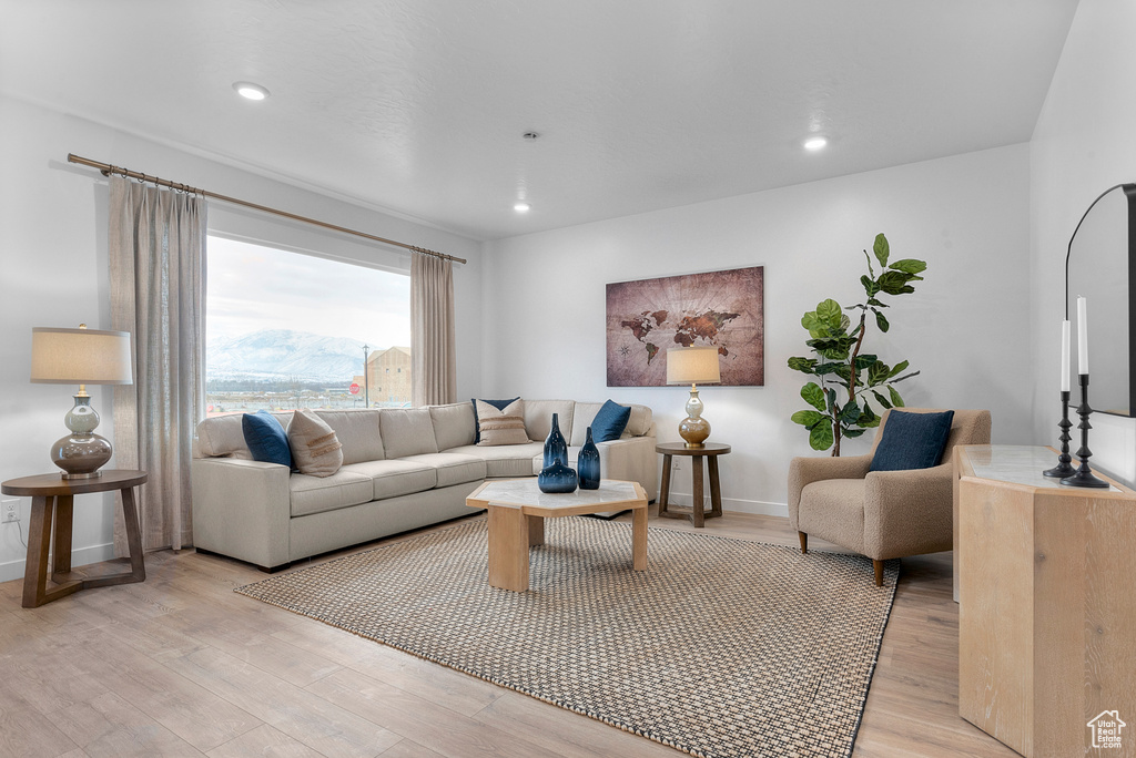 Living area featuring baseboards, recessed lighting, and light wood-style flooring